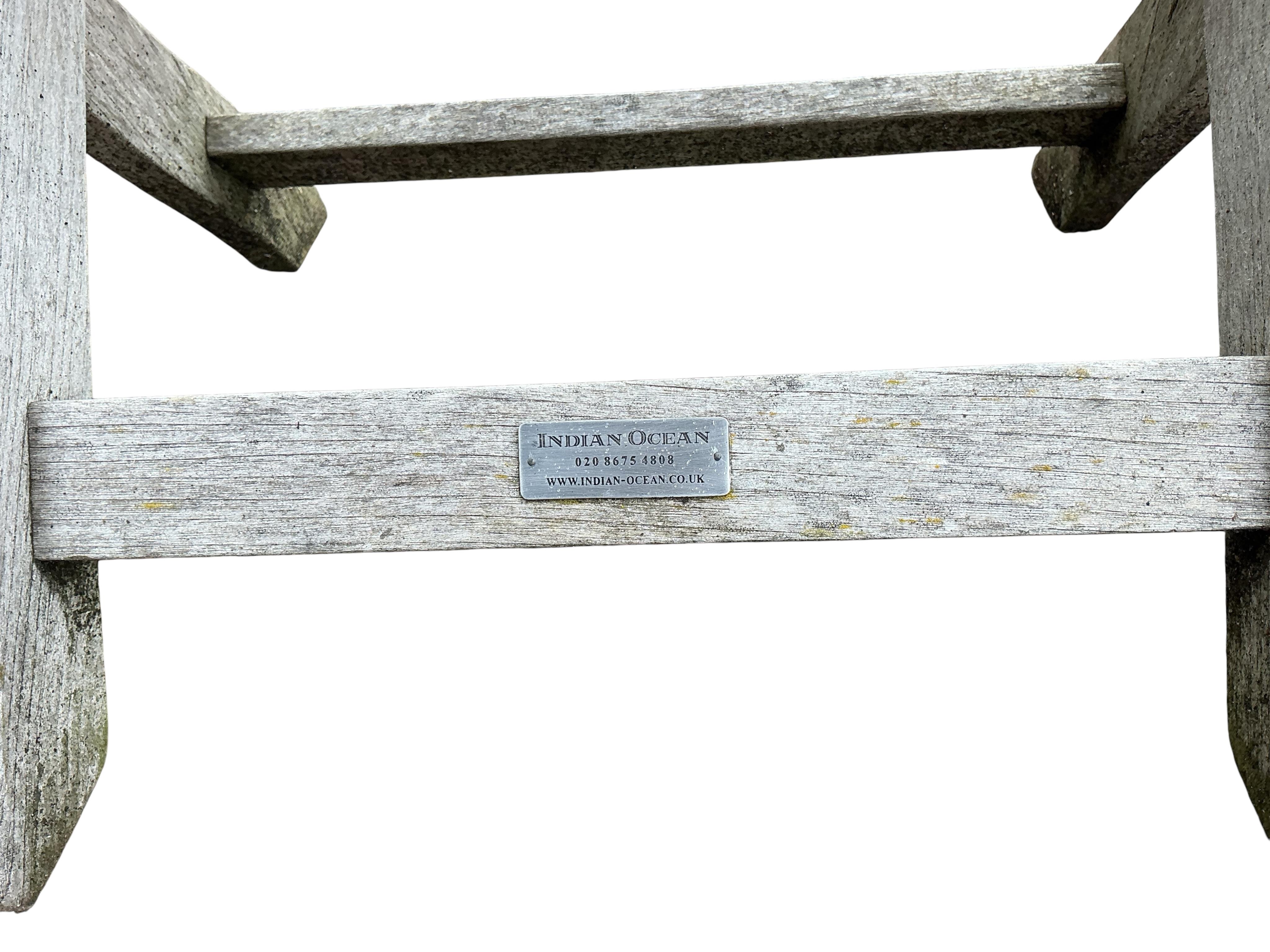 An Indian Ocean Trading Company rectangular teak extending garden table, width 164cm, depth 90cm, height 74cm, four folding chairs and a canvas parasol with metal stand